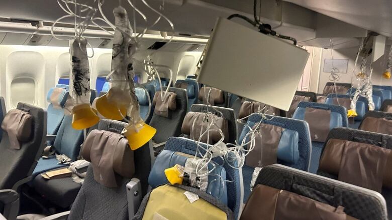 The inside of a plane with oxygen masks hanging