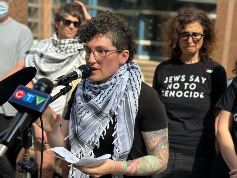 Rachel Small with World Beyond War speaks at a protest outside Toronto police headquarters on Wednesday, May 22, 2024. 