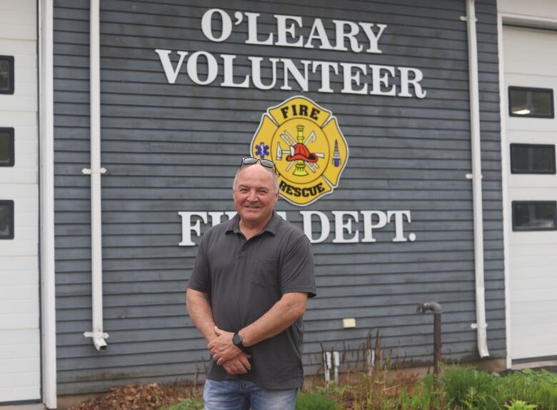 A man stands in front of a building with the words 