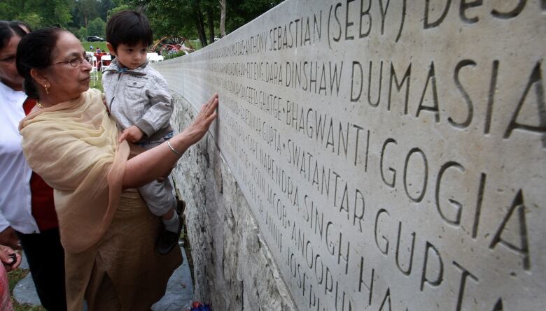 Jagit Grewal, left, shows her two-year-old grandson Devin Grewal the names of her husband, Daljit Singh Grewal, and his grandfather on a monument during a memorial marking the 25th anniversary of the Air India bombing in Vancouver, B.C., on Tuesday June 23, 2010. Air India Flight 182 exploded in the sky off the Irish coast on June 23, 1985, killing all 329 people aboard, 278 of them Canadians.