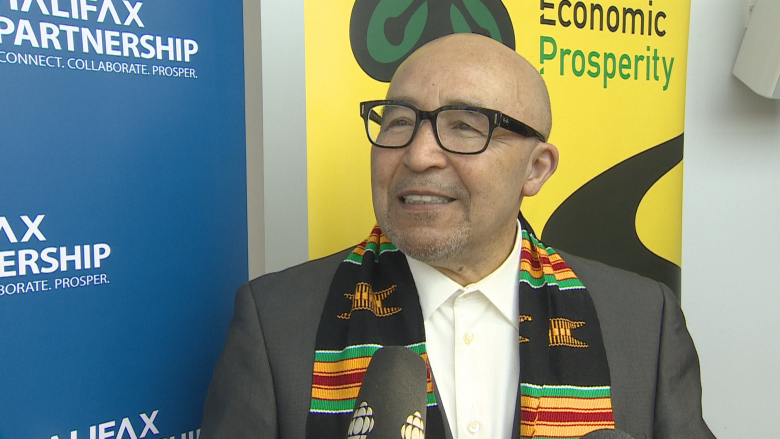 A middle aged man is shown smiling at the camera after speaking with reports about his work on the African Nova Scotian Economic Index. 