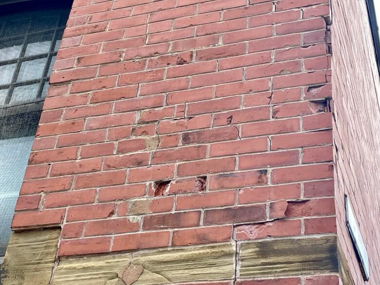 A crumbling wall of red brick