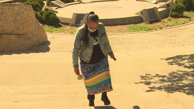 A woman walks up some stairs. 