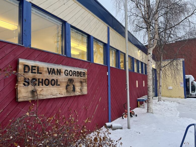 A sign on the side of a building reads, Del Van Gorder school.