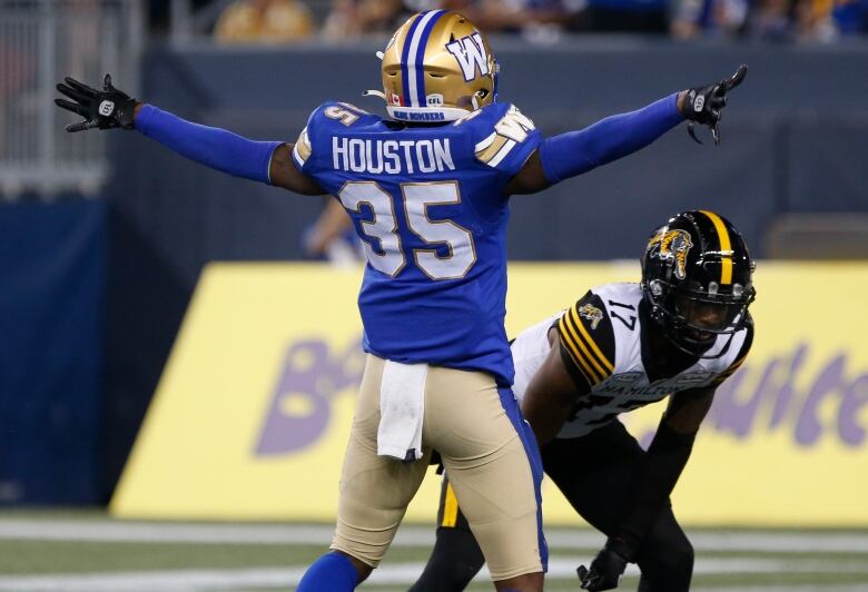 A football player is pictured with his hands extended out.