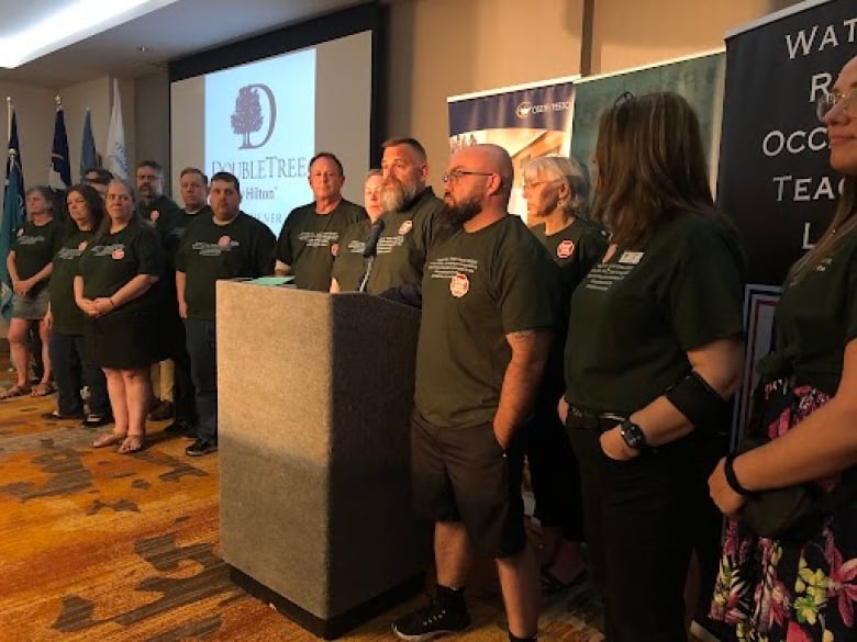 A group of people stand at a podium.