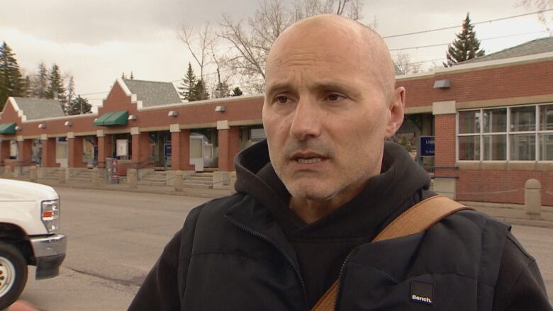 A man stands in front of a C-train station