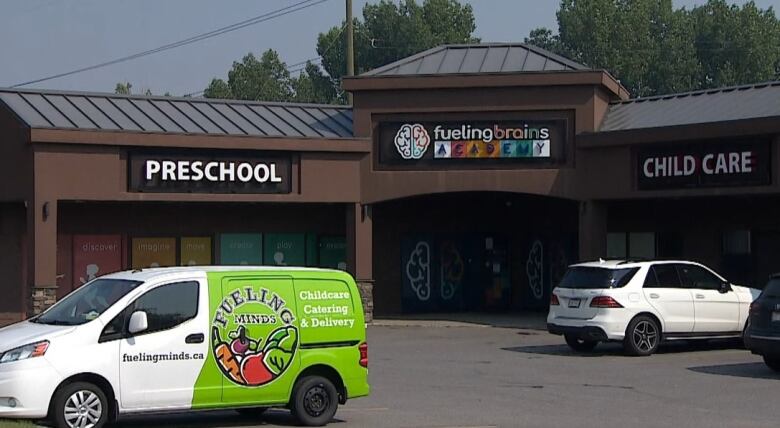 A panel van with a sign that reads Fueling Minds - Childcare Catering & Delivery is seen in the parking lot of Fueling Brains Academy, a daycare centre and preschool. 