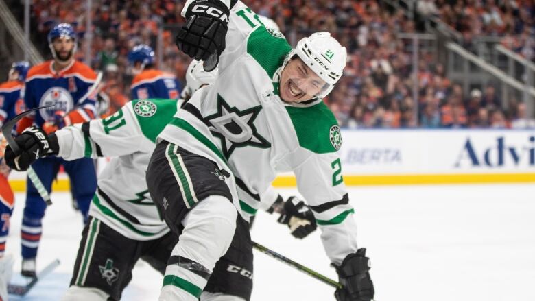 A hockey play celebrates on the ice after scoring a goal.