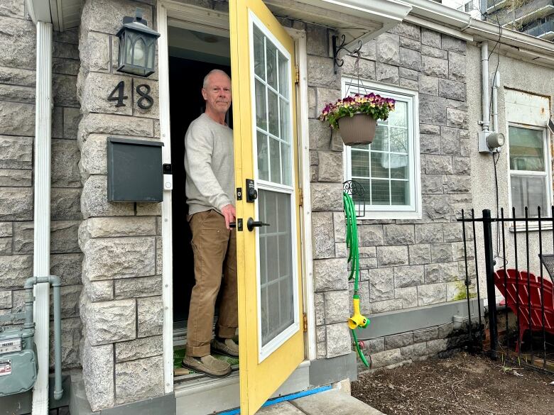 Man closes yellow front door