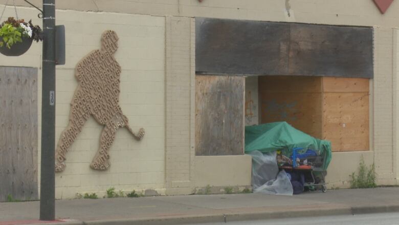 A closed hockey arena with an alcove occupied by a homeless individual's belongings.