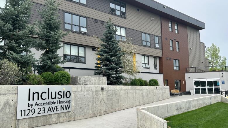 The outside of a residential building, with a sign out front that reads 