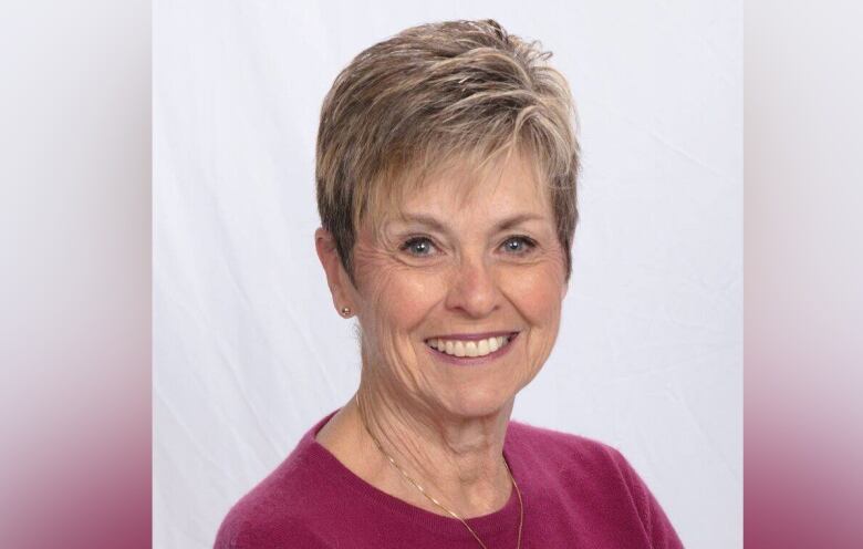 Woman with short hair smiles at the camera.