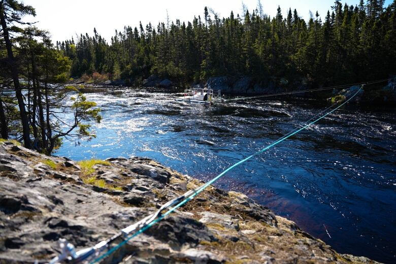 Rope is shown holding a large aluminum floating apparatus in place.