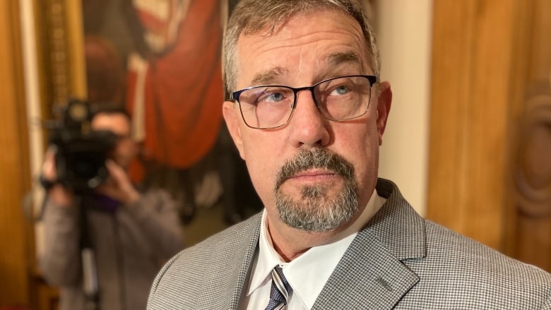 A closeup of a man with glasses and a goatee.