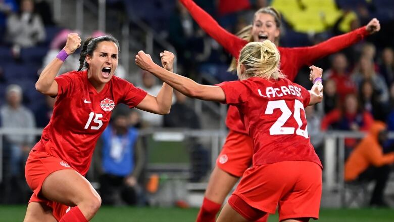 Soccer players celebrate a goal