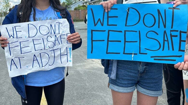 students hold signs that say 