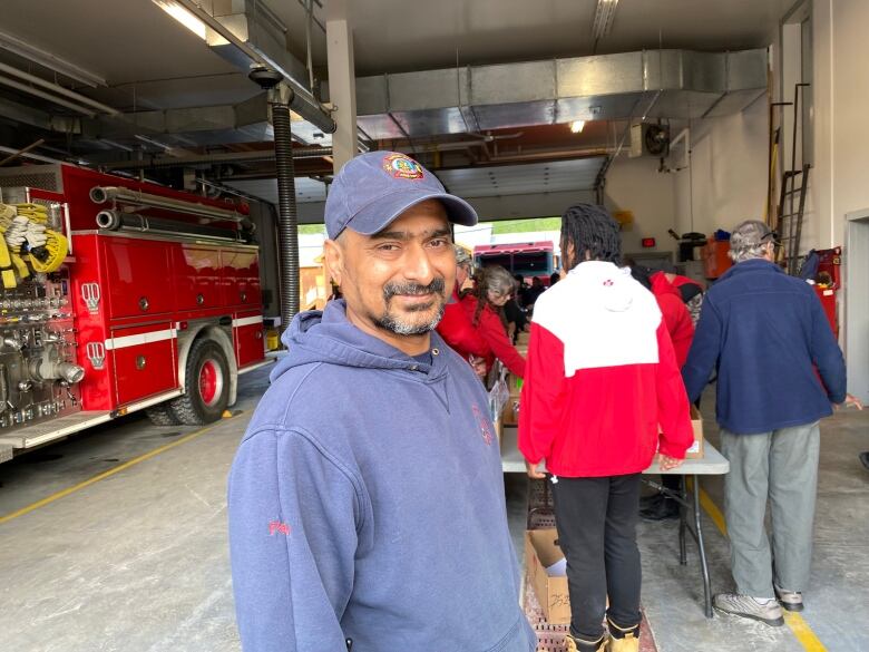 Man smiling while standing infront of a table.