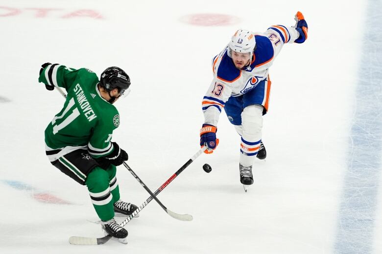 Two hockey players battle for the puck. 