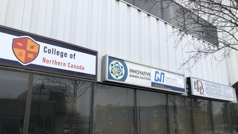 Three signs on the side of a building. 