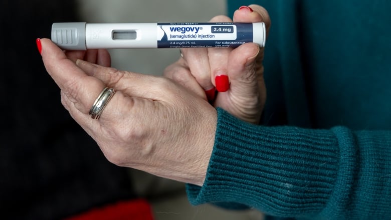 A close of up of two hands holding a tube that says 