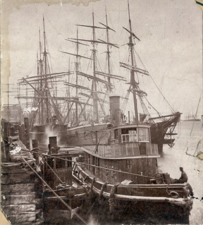 A black and white photo of two tugboats in the age of sail. 