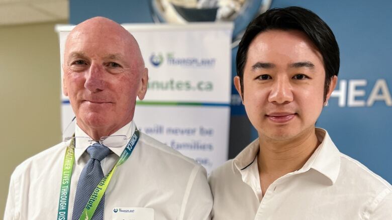 Two scientists standing together look straight ahead.