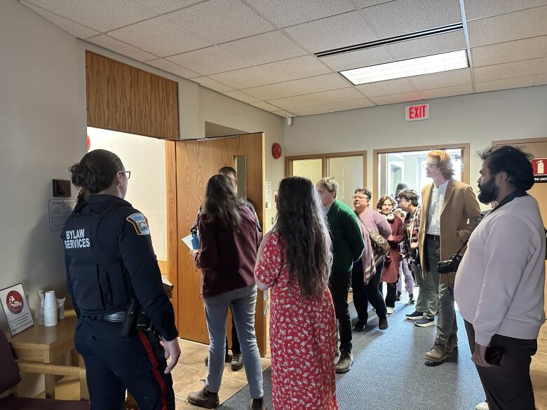 Delegates file past bylaw officers stationed outside Whitehorse city council chambers on Monday, June 3. 