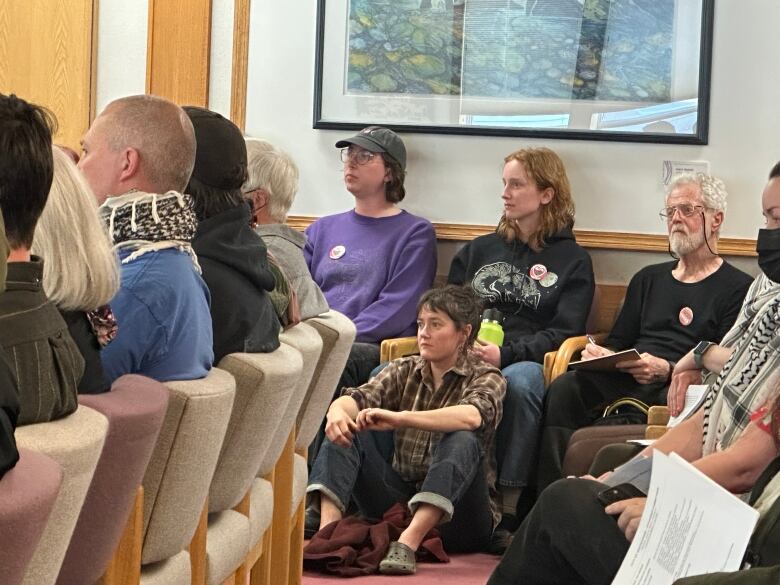 Residents listen to speakers at a city council meeting in Whitehorse on June 3. 