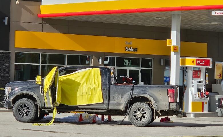 A black pickup truck has yellow police tape on it