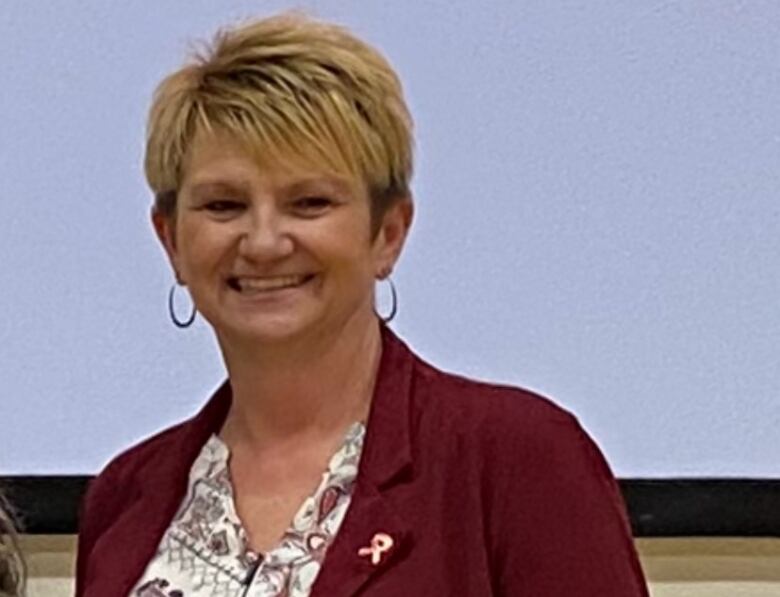 A woman smiles wearing a MADD ribbon.