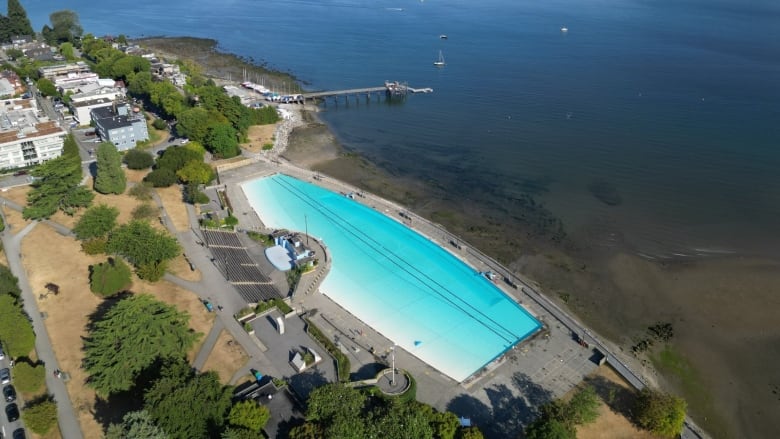 An aerial shot of an outdoor pool on the beach.