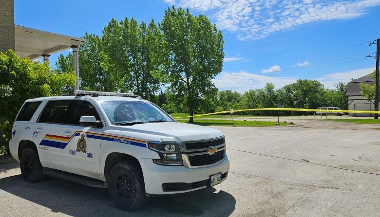 A police cruiser, with police tape behind it.