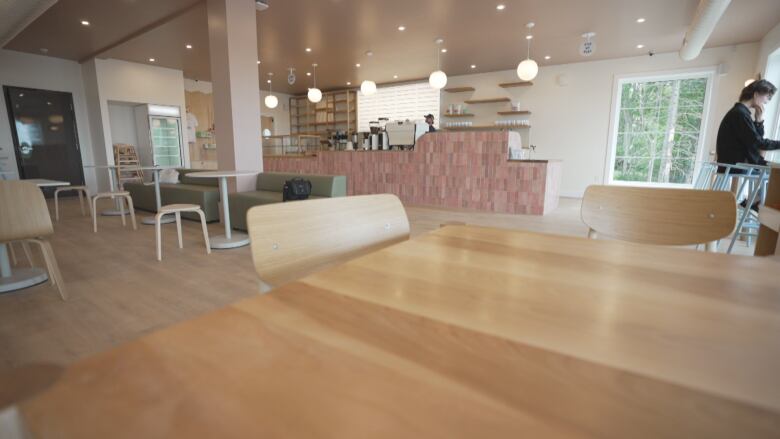 A cafe with a counter near the front and several tables and chairs