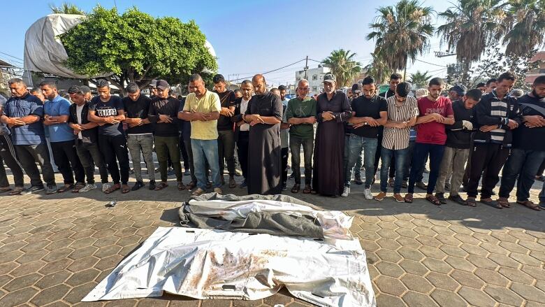 Mourners gather next to the bodies of Palestinians killed in Israeli strikes, amid the Israel-Hamas conflict, during their funeral at Al-Aqsa hospital in Deir Al-Balah, in central Gaza Strip June 6, 2024. 