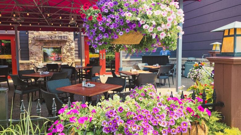 A patio decorated with bright flowers and greenery