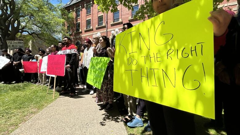 A line of people holding signs.