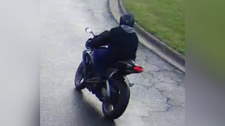 photo of a man on a motorcycle taken from behind.