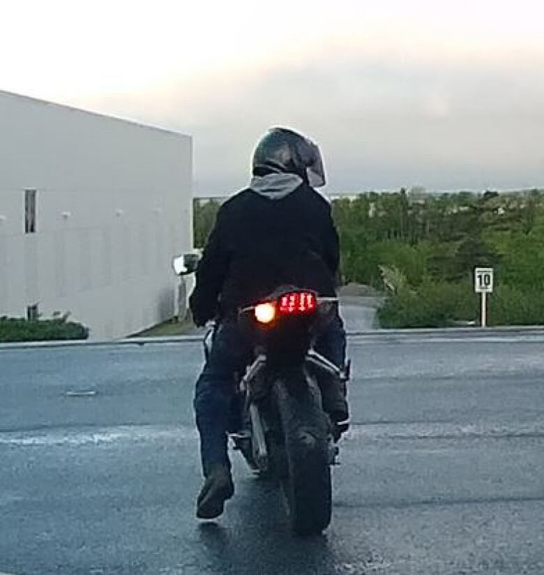 Rear view of man on a motorcycle.