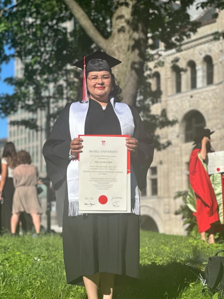 A woman holding her university diploma