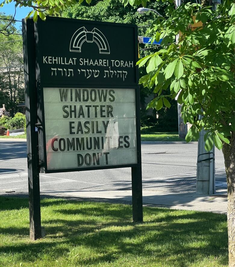 A sign outside a synagogue reads 'Windows shatter easily, communities don't'