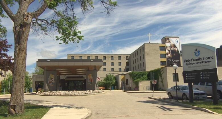 Holy Family Home building and entrance in Winnipeg's north end, under a blue sky with light clouds.