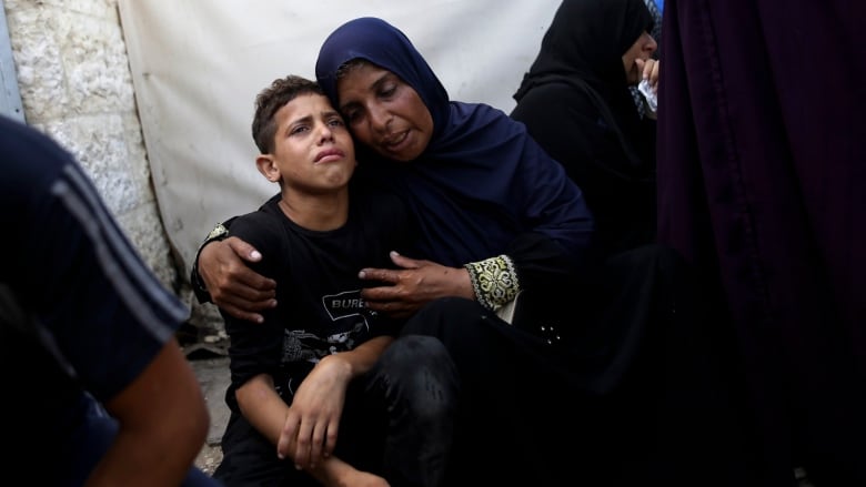 A woman comforts a distraught boy.