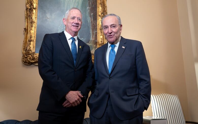 Two people in suits pose for a photograph.