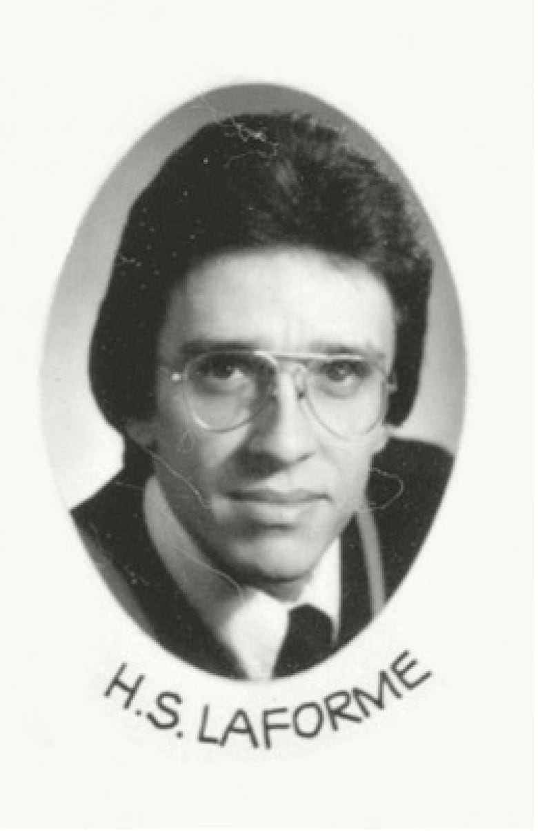 A man is seen in a black and white graduation photo.