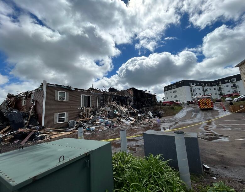 Rubble outside burned-down apartment building.