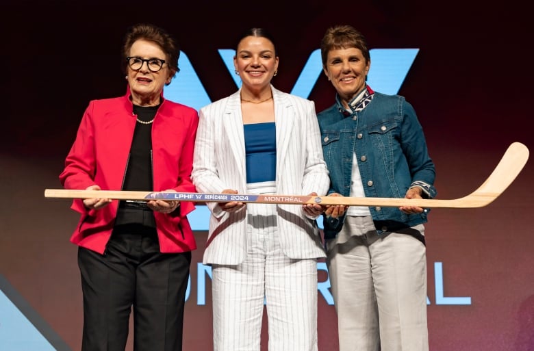 Three women pose for a photo. 