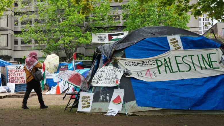 A person walks past the pro-Palestinian encampment on McGill University campus