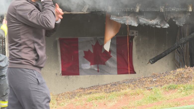 A soiled Canadian flag hangs among the debris. 