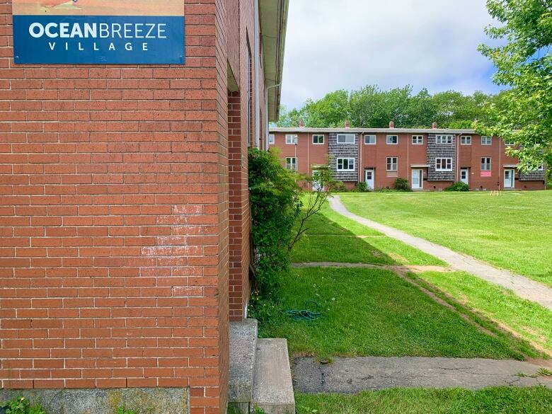 Brick townhouses with a grassy lawn.